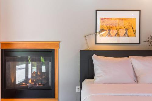 a bedroom with a bed and a fireplace at Rhythm Waters by AvantStay Garden Paradise Pond in Langley