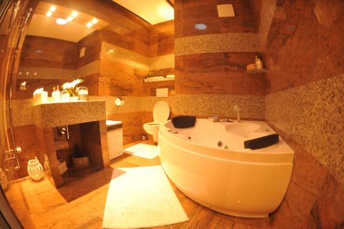 شقة لوباكوفا في براغ: حمام كبير مع حوض استحمام ومرحاض