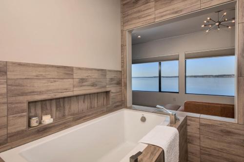 a bathroom with a white tub and a window at Langley Waterfront Condo by AvantStay A Views in Langley