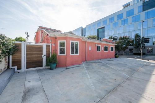 a red building in a parking lot next to a building at Urban Jungle by AvantStay A Location Steps to Hollywood Must-Sees in Los Angeles