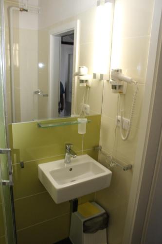 a bathroom with a sink and a mirror at Hotel Centrum Brno in Brno