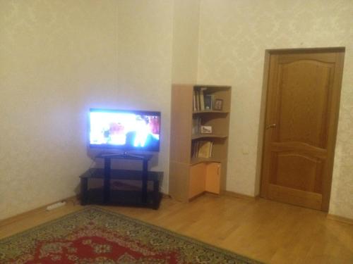 a living room with a television and a door at Apartment Na Gazone in Velikiy Novgorod
