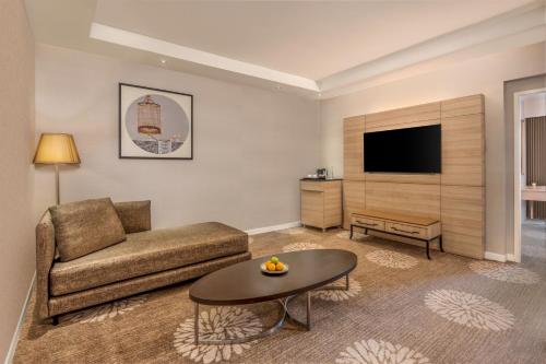 a living room with a couch and a table at Dusit Princess Melaka in Melaka