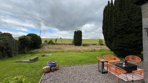 a patio with a table and chairs in a yard at KIRK - Gorgeous church in the heart of Fife converted into a warm home in Milton of Balgonie