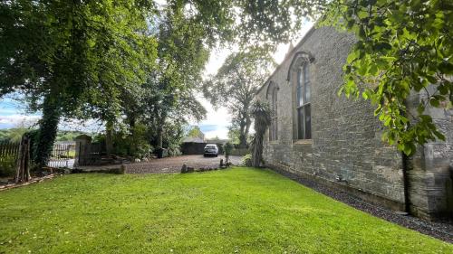 a car parked in a yard next to a building at KIRK - Gorgeous church in the heart of Fife converted into a warm home in Milton of Balgonie