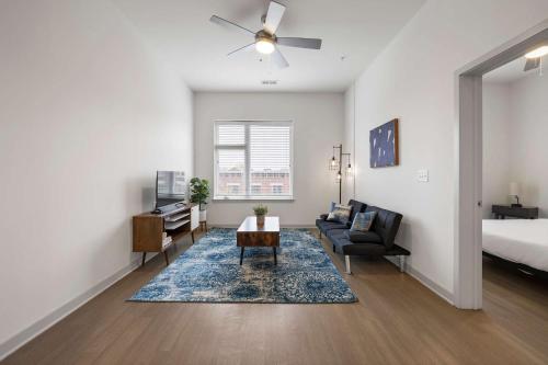 a living room with a bed and a couch and a table at Stunning Nulu 1BR CozySuites 07 in Louisville