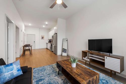 a living room with a couch and a tv at Stunning Nulu 1BR CozySuites 07 in Louisville