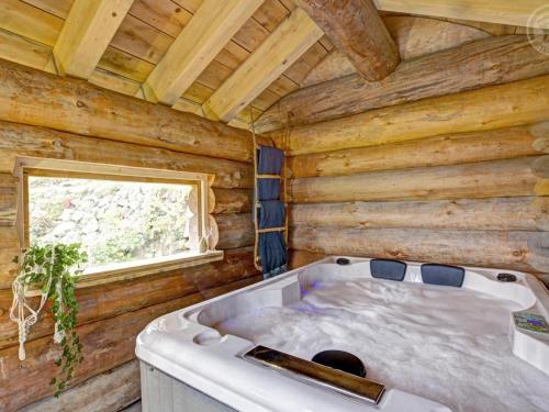 una vasca da bagno in una stanza con una finestra di Gîte de charme avec poêle à bois, billard et terrasse dans les Monts du Forez - FR-1-496-313 a Saint-Jean-Soleymieux