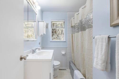 a white bathroom with a sink and a toilet at Eagles Watch by AvantStay Large Deck w Views in Coupeville