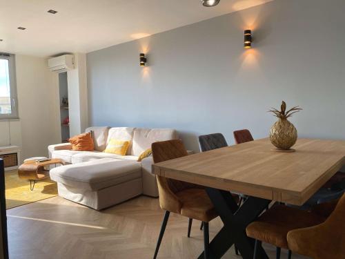 un salon avec une table et un canapé dans l'établissement Spacieux T2, dernier étage, confort moderne, Wi-Fi, Balaruc-les-Bains - FR-1-553-276, à Balaruc-les-Bains