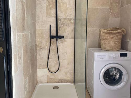 une douche dans une salle de bain avec machine à laver dans l'établissement Spacieux T2, dernier étage, confort moderne, Wi-Fi, Balaruc-les-Bains - FR-1-553-276, à Balaruc-les-Bains