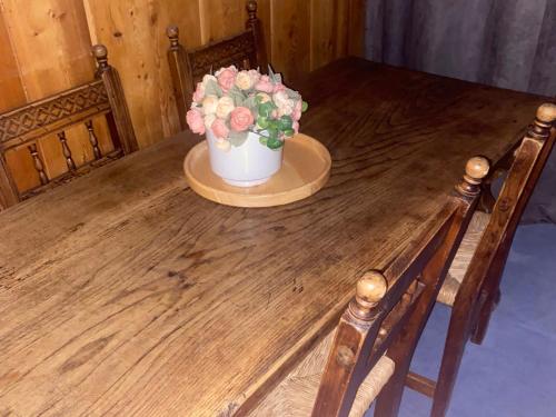 une table en bois avec un vase de fleurs dessus dans l'établissement Studio - 3 Pers - Centre de Val d'Isère - Pied des Pistes - WIFI & TV - Cuisine équipée - FR-1-519-38, à Val dʼIsère