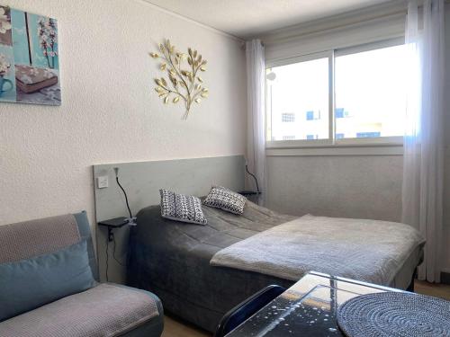 une chambre avec deux lits et une chaise et une fenêtre dans l'établissement Studio confort avec climatisation et wifi à Balaruc-les-Bains - FR-1-553-278, à Balaruc-les-Bains