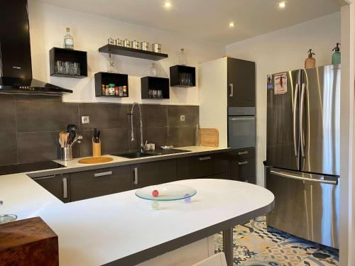 Il comprend une cuisine équipée d'un réfrigérateur et d'un comptoir blanc. dans l'établissement Balaruc-les-Bains: Appartement spacieux avec jardin, clim, parking et wifi - FR-1-553-280, à Balaruc-les-Bains