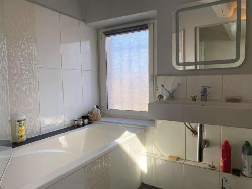 une salle de bain blanche avec une baignoire et un lavabo dans l'établissement Balaruc-les-Bains: Appartement spacieux avec jardin, clim, parking et wifi - FR-1-553-280, à Balaruc-les-Bains