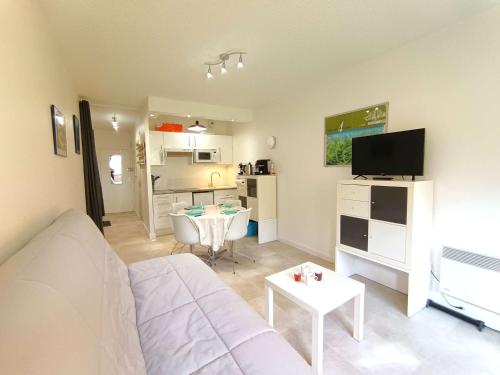 un salon avec un canapé blanc et une table dans l'établissement Studio cosy pour 4 avec balcon et parking à Saint-Lary-Soulan - FR-1-457-360, à Saint-Lary-Soulan