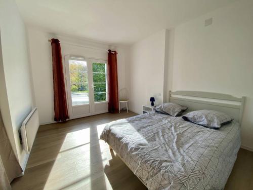 a white bedroom with a bed and a window at T2 charmant à Cambo-les-Bains, proche Thermes, WIFI, 2 couchages - FR-1-495-146 in Cambo-les-Bains