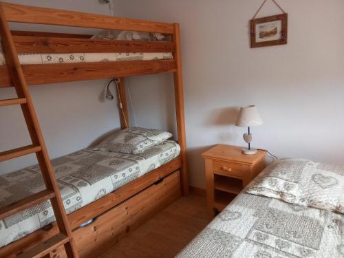 une chambre avec deux lits superposés et une lampe dans l'établissement Appartement 6 pers, proche pistes & navette, parking - FR-1-467-144, au Grand-Bornand
