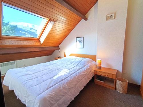 une chambre avec un grand lit avec une fenêtre dans l'établissement Duplex T3 6 pers - Saint-Lary-Soulan avec TV, parking, casier à skis - FR-1-457-352, à Saint-Lary-Soulan