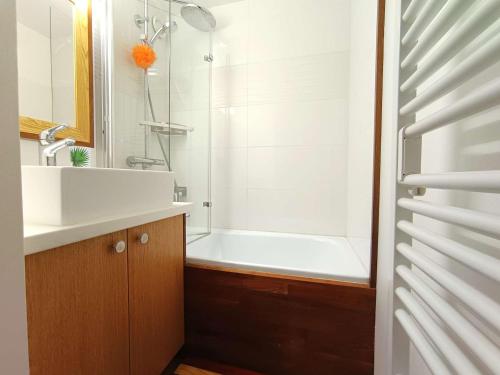 une salle de bain avec une baignoire blanche et un lavabo dans l'établissement Duplex T3 6 pers - Saint-Lary-Soulan avec TV, parking, casier à skis - FR-1-457-352, à Saint-Lary-Soulan