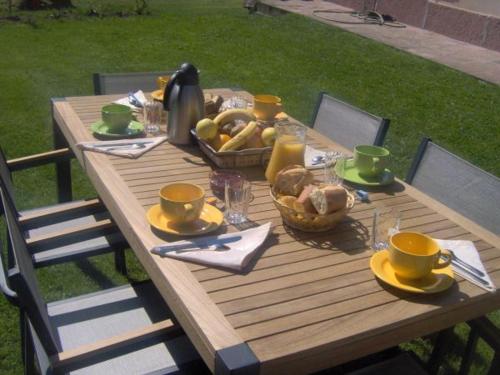 une table en bois avec un panier de nourriture dessus dans l'établissement Chambre Iris dans bâtisse rénovée au cœur de la nature - FR-1-589-726, à Moyenmoutier