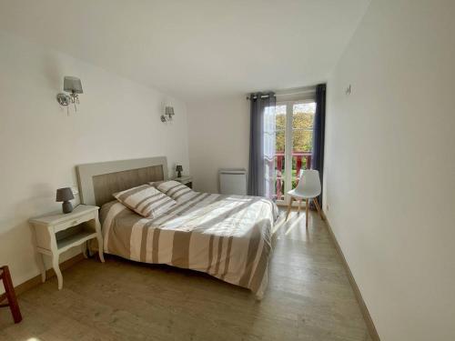 ein weißes Schlafzimmer mit einem Bett und einem Fenster in der Unterkunft Appartement T3 rénové avec WIFI, proche des Thermes de Cambo-les-Bains - FR-1-495-145 in Cambo-les-Bains