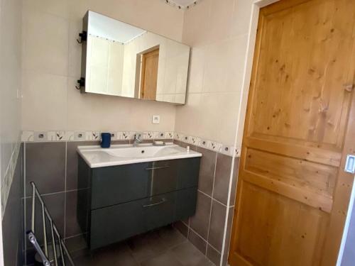 ein Badezimmer mit Waschbecken, Spiegel und Tür in der Unterkunft Appartement T3 rénové avec WIFI, proche des Thermes de Cambo-les-Bains - FR-1-495-145 in Cambo-les-Bains