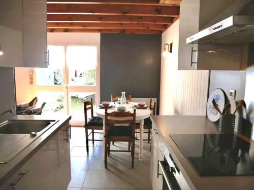 une cuisine avec une table et une salle à manger dans l'établissement Erdeven, Maison cosy 3 pièces avec terrasse et parking, proche plage - FR-1-479-174, à Erdeven