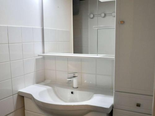 une salle de bain blanche avec un lavabo et un miroir dans l'établissement Erdeven, Maison cosy 3 pièces avec terrasse et parking, proche plage - FR-1-479-174, à Erdeven
