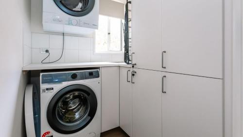 a laundry room with a washing machine and a microwave at The Holiday Shack at Flinders in Flinders
