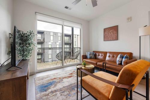 a living room with a couch and a large window at Modern Nulu 2BR CozySuites 09 in Louisville