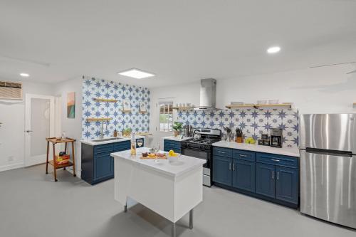 a kitchen with blue cabinets and a white counter top at Fable by AvantStay 2 Unique Spaces w Bowling Hot Tub Fire Pit Large Yard in Joshua Tree