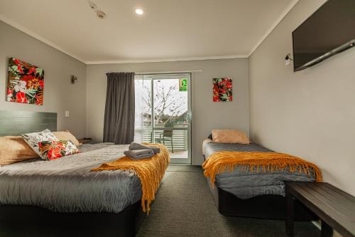 a bedroom with two beds and a window at Ivorytowers Accommodation in Fox Glacier