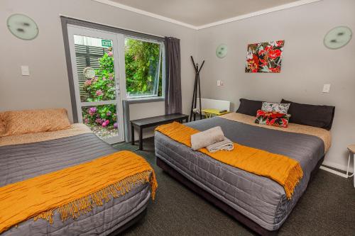 a bedroom with two beds and a window at Ivorytowers Accommodation in Fox Glacier