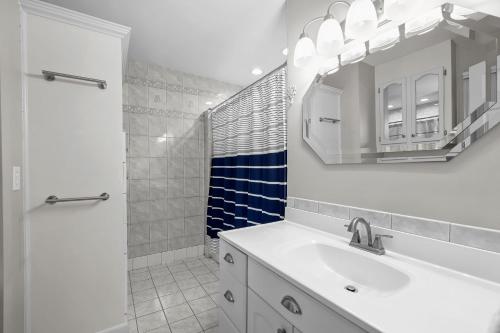 a bathroom with a sink and a mirror and a shower at Sip Sip Away by AvantStay Pool Hot Tub in Westport