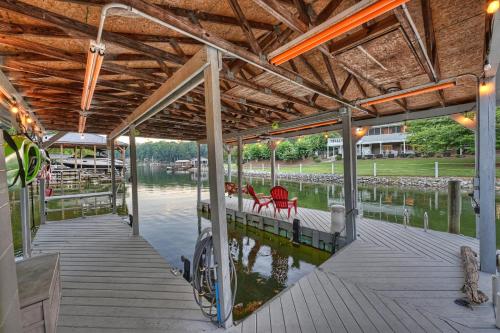 a dock with red chairs on the water at Sip Sip Away by AvantStay Pool Hot Tub in Westport