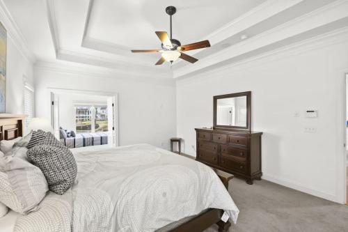 a white bedroom with a ceiling fan and a bed at Lake Escape by AvantStay Lakefront Private Dock in Mooresville