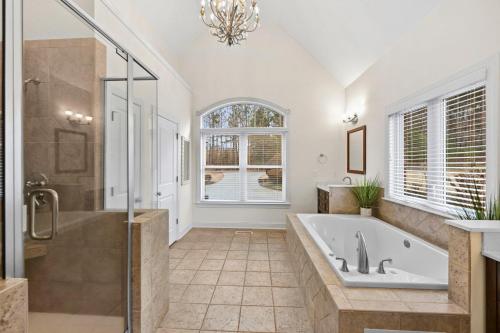 a bathroom with a tub and a shower and a sink at Lake Escape by AvantStay Lakefront Private Dock in Mooresville