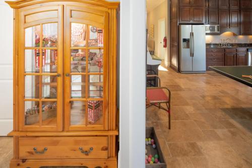 a kitchen with a wooden china cabinet and a living room at Flip Flop Therapy by AvantStay Lakefront Home w Game Room Dock Access in Mooresville