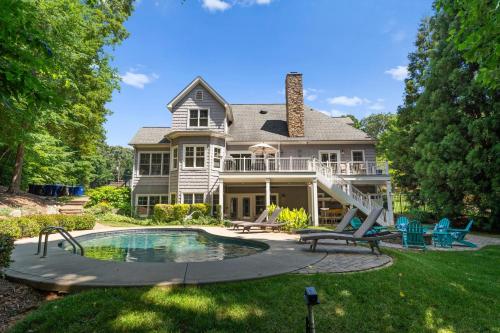 a house with a swimming pool in the yard at Making Waves by AvantStay Sleeps 20 Pool in Westport