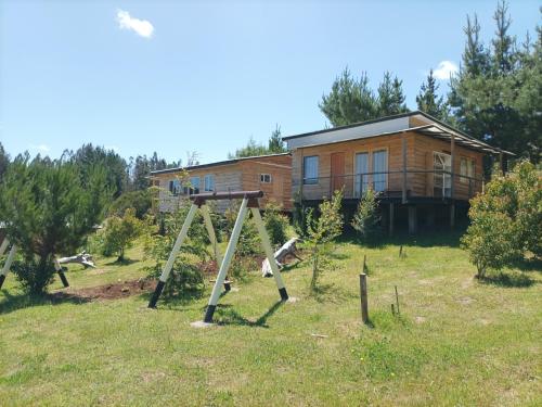 een huis met een speeltuin ervoor bij Cabañas y Agroturismo El Trolofken in Pocuno