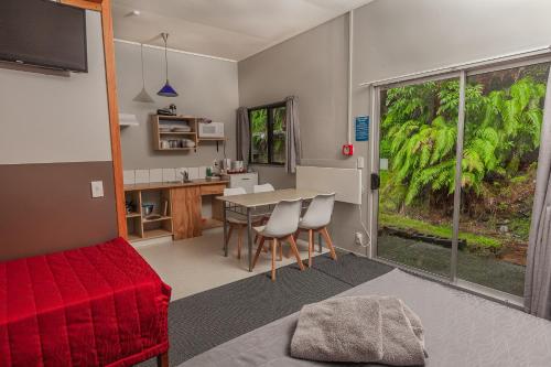 a living room with a red couch and a table at Ivorytowers Accommodation in Fox Glacier