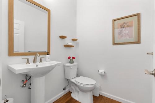 a bathroom with a sink and a toilet and a mirror at Makaha Villa by AvantStay Mountain Ocean Views in Waianae