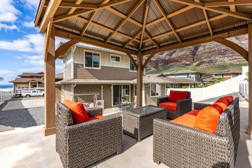 an outdoor patio with two chairs and a pergola at Makaha Villa by AvantStay Mountain Ocean Views in Waianae
