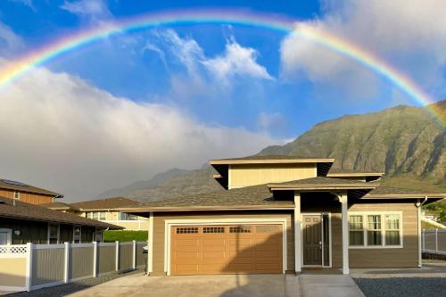 a rainbow in the sky over a house at Makaha Villa by AvantStay Mountain Ocean Views in Waianae