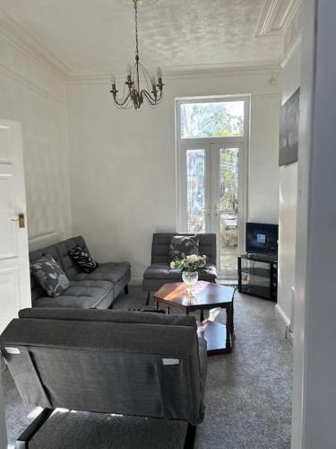 a living room with a couch and a table at Spacious Grimsby Contractor Friendly Home Sleeps 12 and Free Parking in Grimsby
