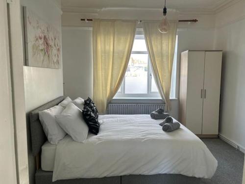 a bedroom with a large bed with a window at Spacious Grimsby Contractor Friendly Home Sleeps 12 and Free Parking in Grimsby