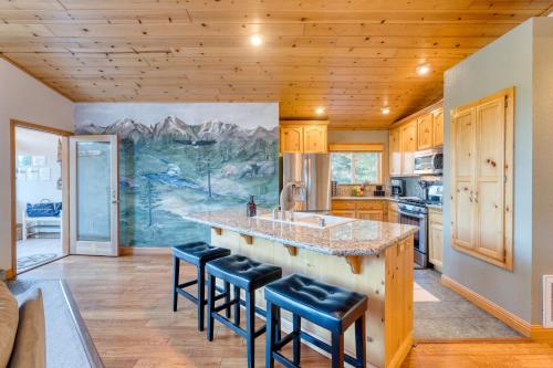 a kitchen with a large island with bar stools at Golden Summit by AvantStay Stunning Secluded Cabin w Access to Tahoe Donner in Truckee