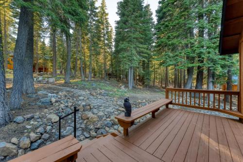 a cat sitting on a bench on a wooden deck at Golden Summit by AvantStay Stunning Secluded Cabin w Access to Tahoe Donner in Truckee