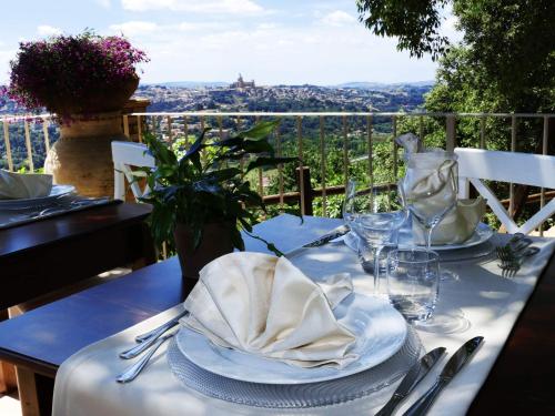 a table with plates and napkins on a table with a view at Torre di Renda in Piazza Armerina